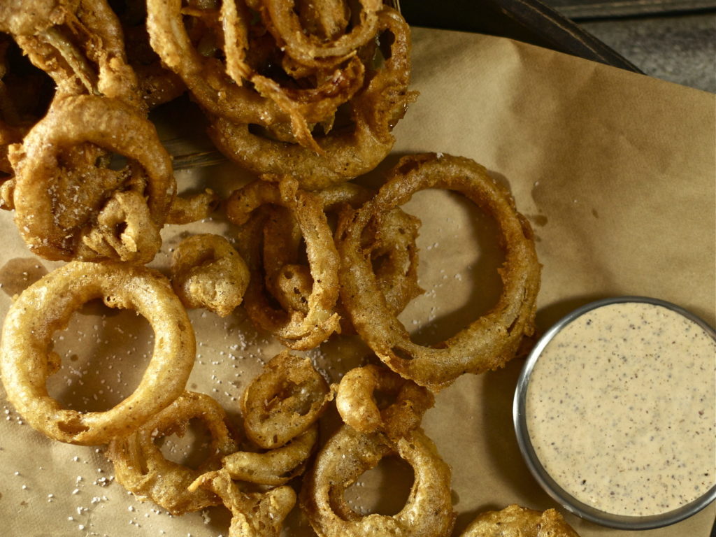 Onion rings spilled out on butcher paper